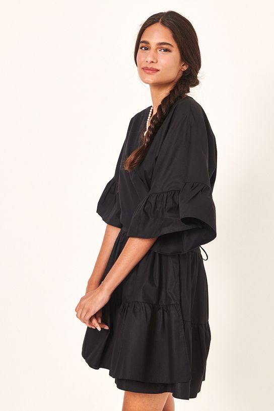 modelo de lado usando vestido curto algodão transpassado preto